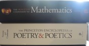 A picture of the Sun peeking over the spine of The Princeton Companion to Mathematics as it rests on top of The Princeton Encyclopedia of Poetry & Poetics