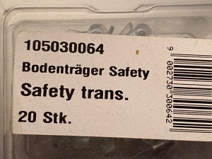 A small, transparent plastic container with a label saying: 105030064 Bodenträger Safety Safety Trans. 20 Stk.